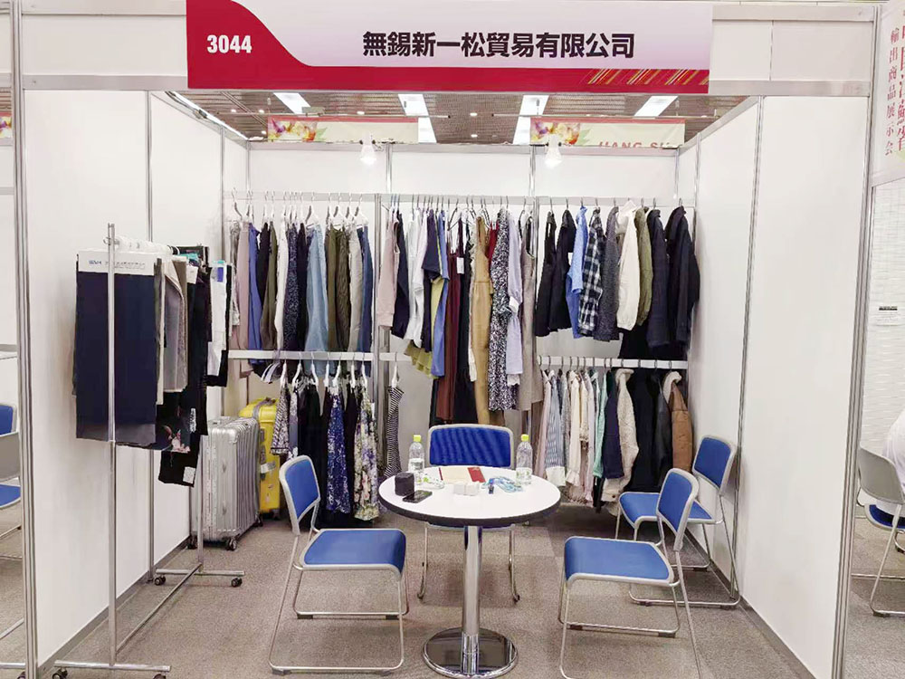 Clothing supplier booth showcasing OEM apparel collections at trade show
