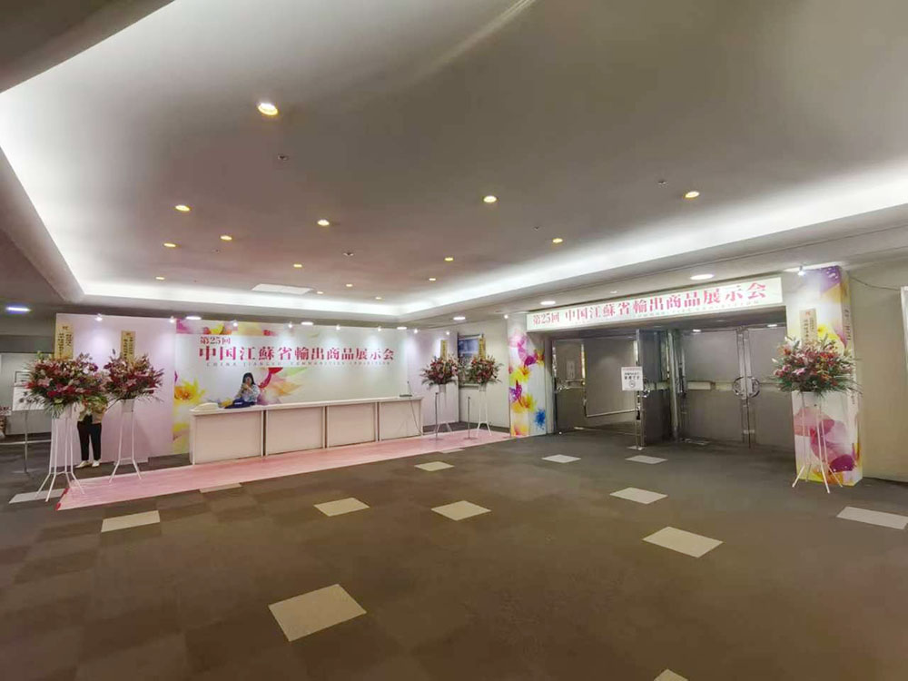 apparel trade show exhibition hall entrance with floral reception setup